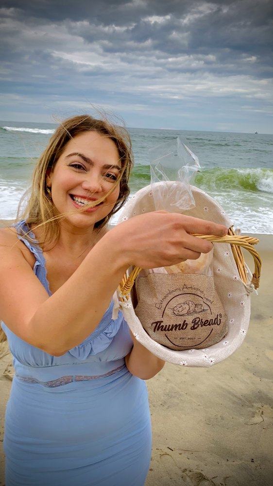 Arzu Esendemir holding Thumb Bread® in the burlap bag at the beach