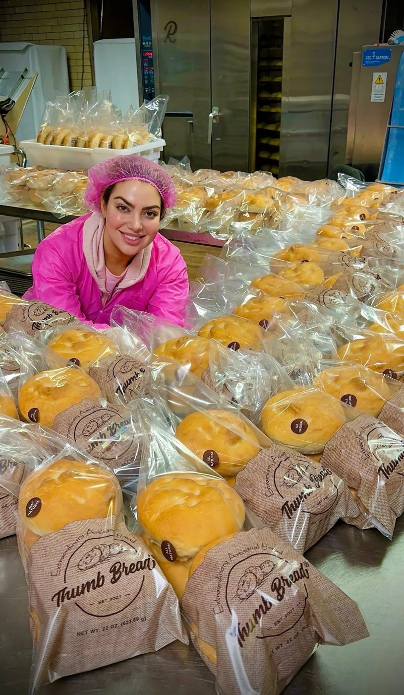 Arzu Esendemir surrounded by freshly packed Thumb Bread® in burlap bags