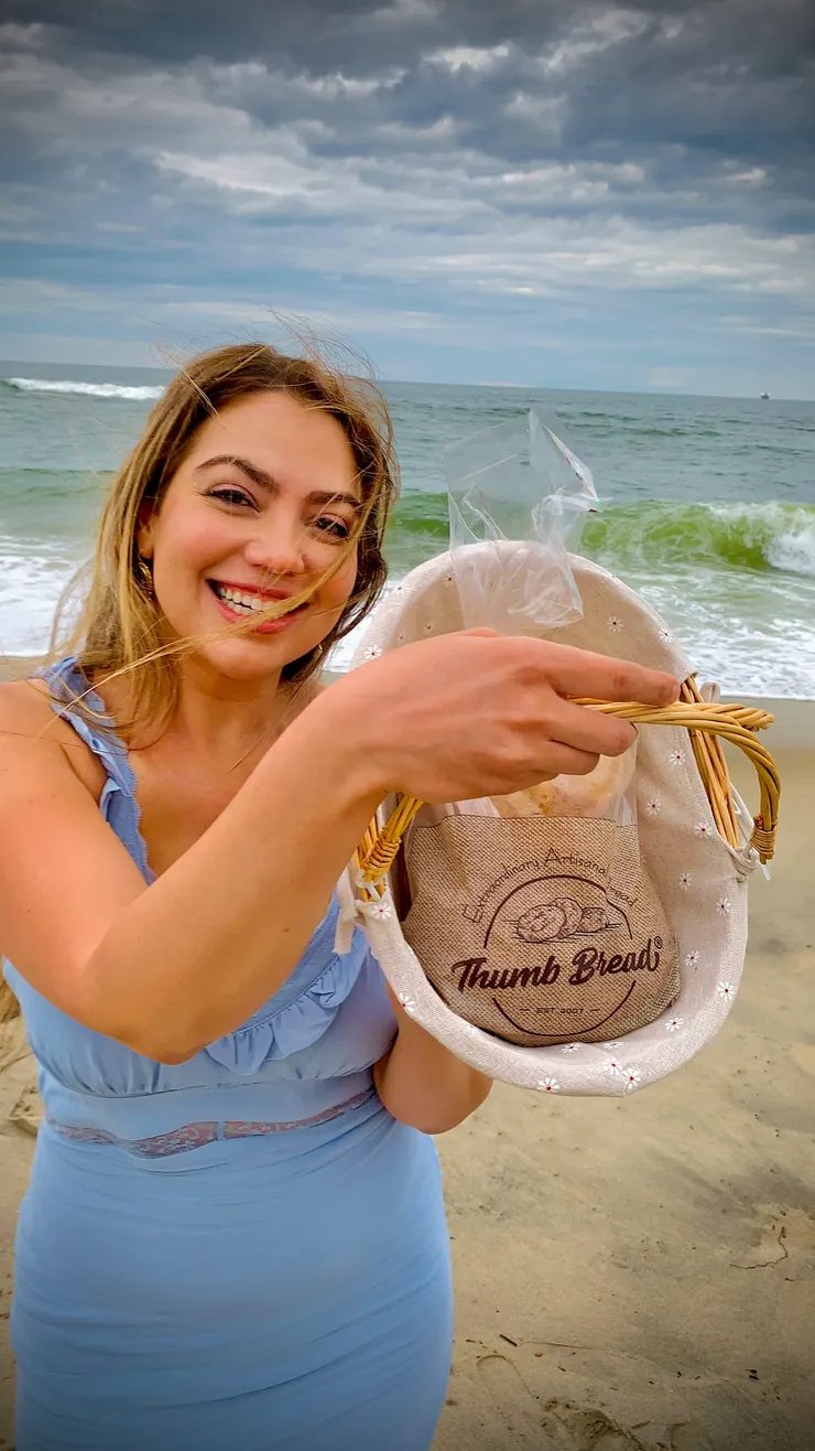 Arzu Esendemir holding a bag of Thumb Bread® at the beach