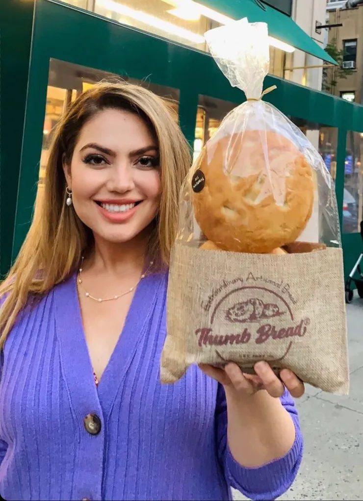 Arzu Esendemir holding Thumb Bread® in the burlap bag on a city street