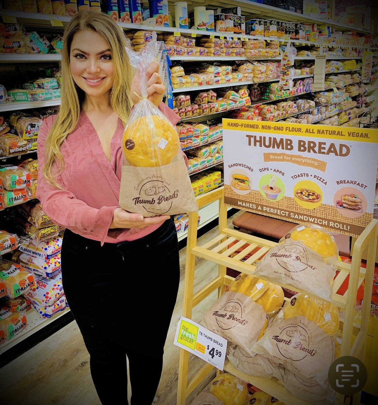 Arzu Esendemir holding Thumb Bread® next to a Thumb Bread® display in the bread aisle at The Fresh Grocer