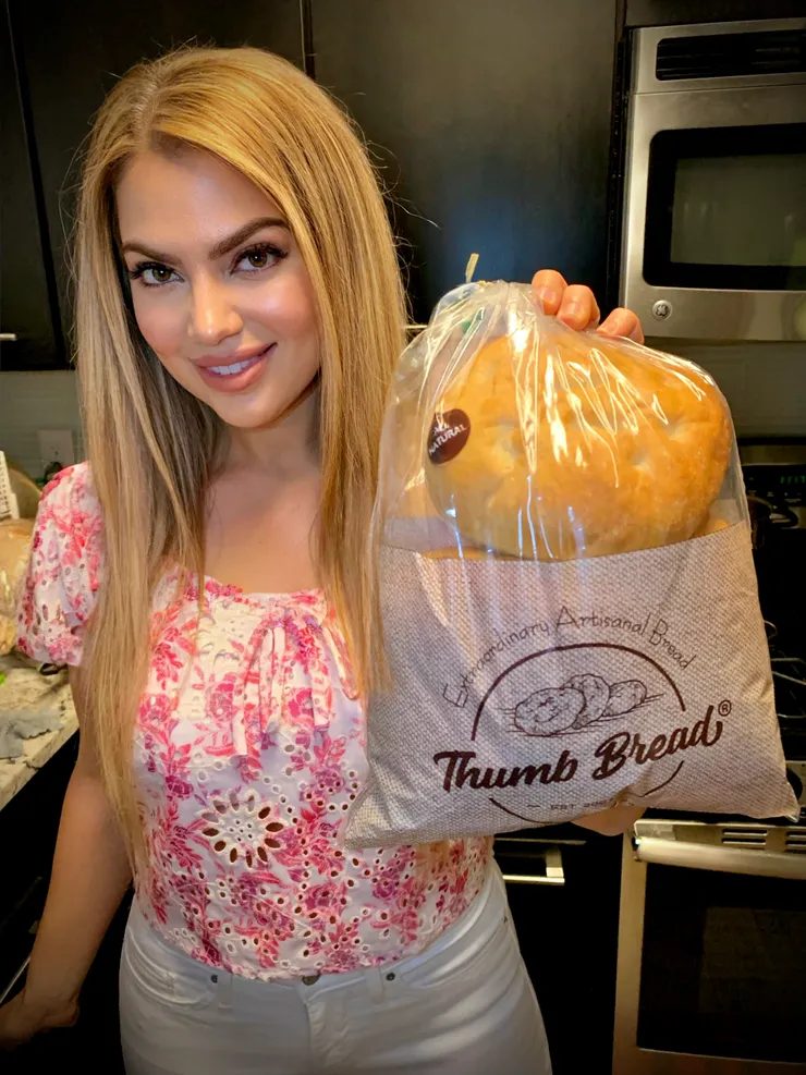 Arzu Esendemir holding Thumb Bread® in the burlap bag in her kitchen