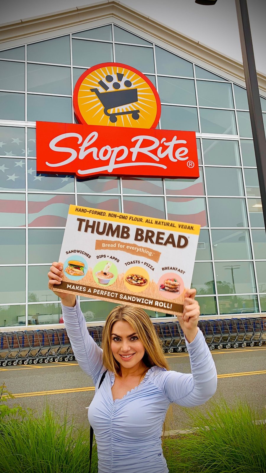 Arzu Esendemir holding up a Thumb Bread® sign under the ShopRite store sign