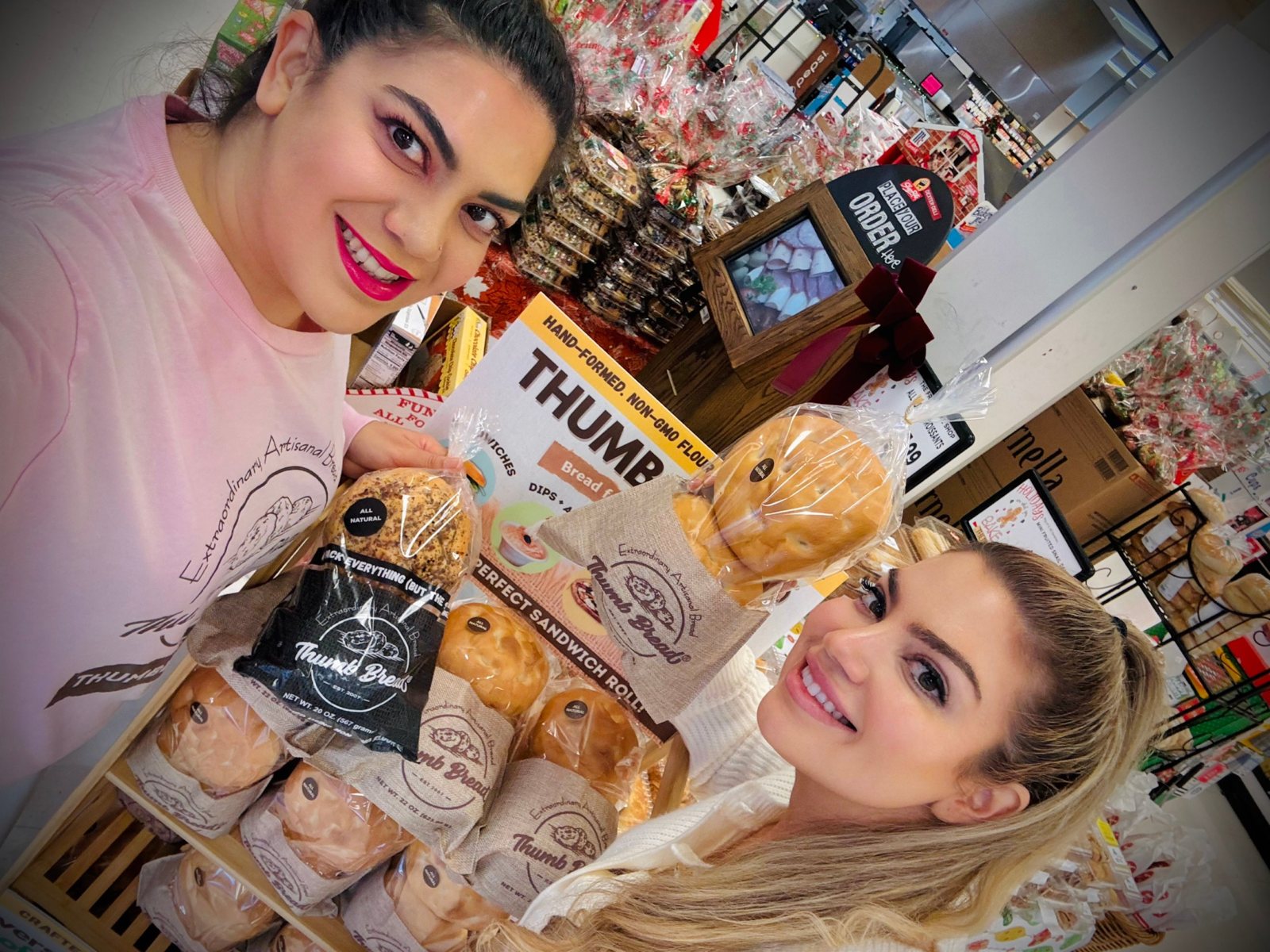 Gonca Esendemir and Arzu Esendemir holding bags of Thumb Bread® in front of a Thumb Bread® display at ShopRite