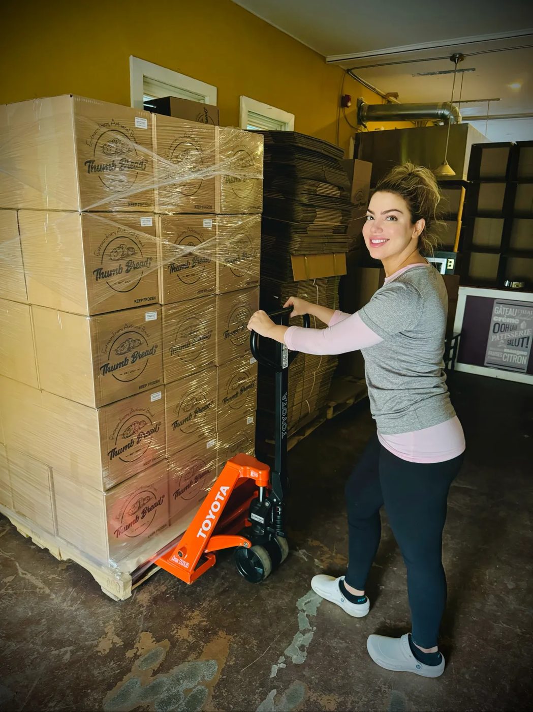 One of the Esendemir sisters moving a pallet of Thumb Bread® boxes