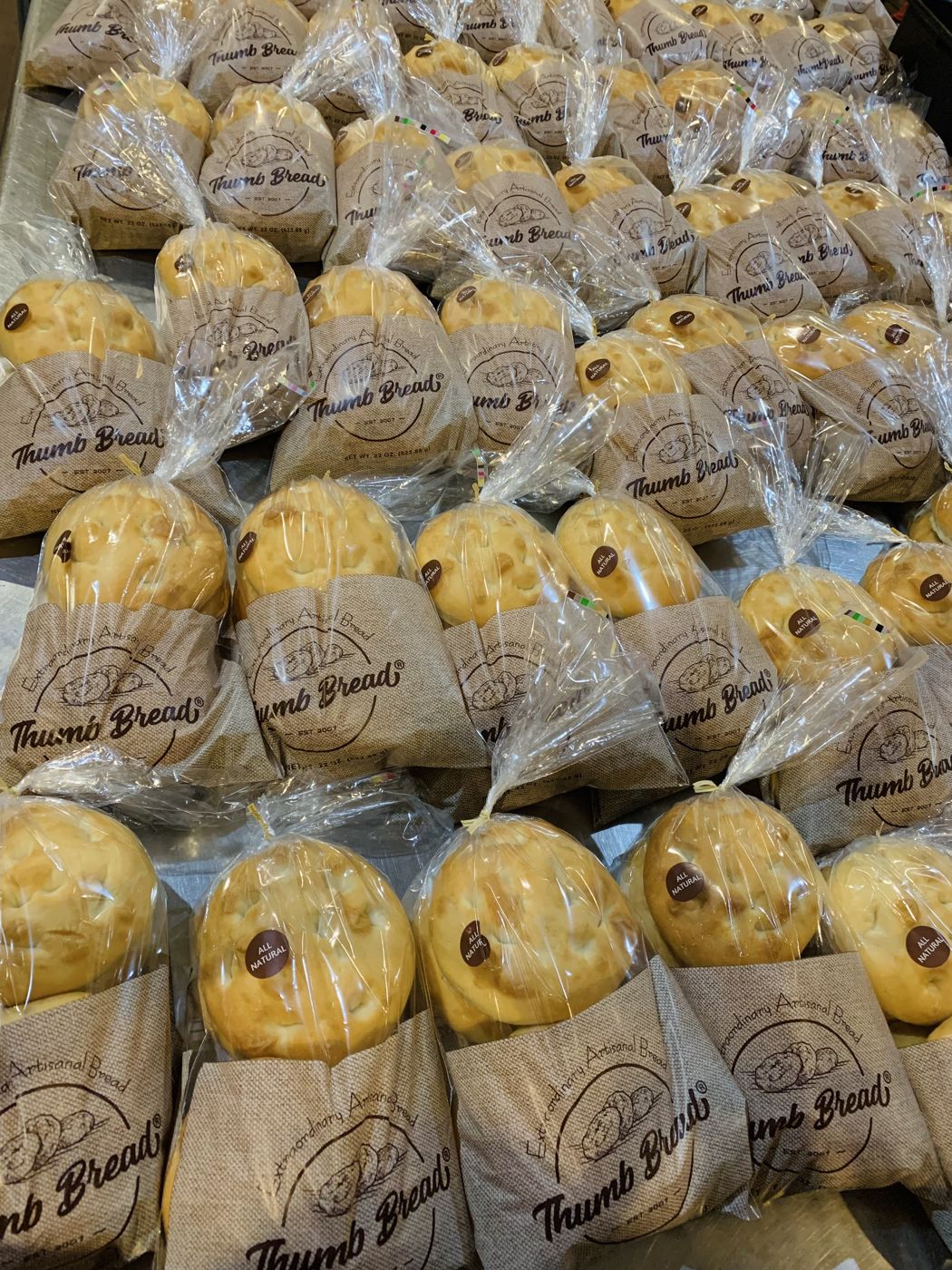 Stacks of Thumb Bread® in its burlap bread bags