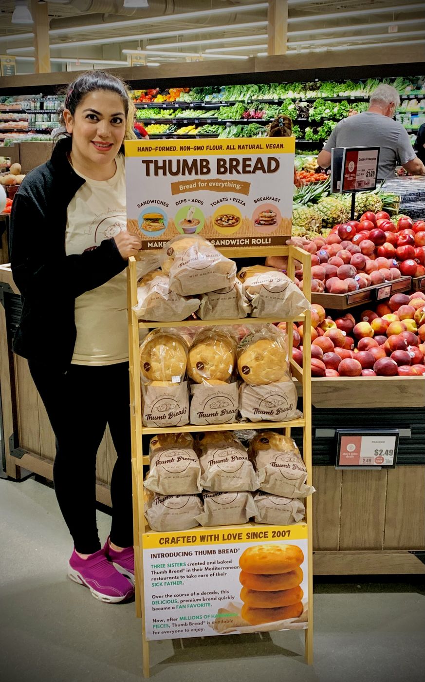 One of the Esendemir sisters next to a Thumb Bread® display rack at ShopRite