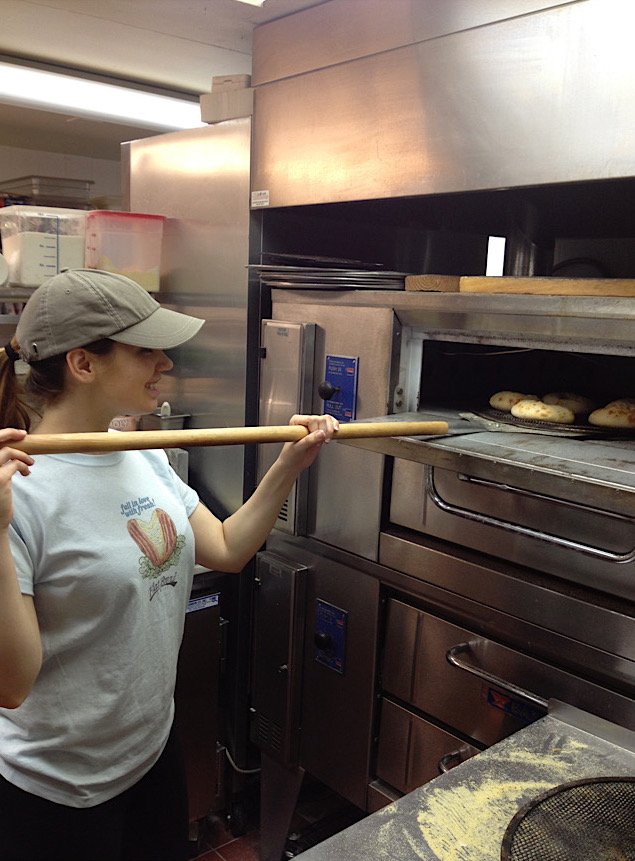 One of the Esendemir sisters pulling fresh flatbreads from the oven