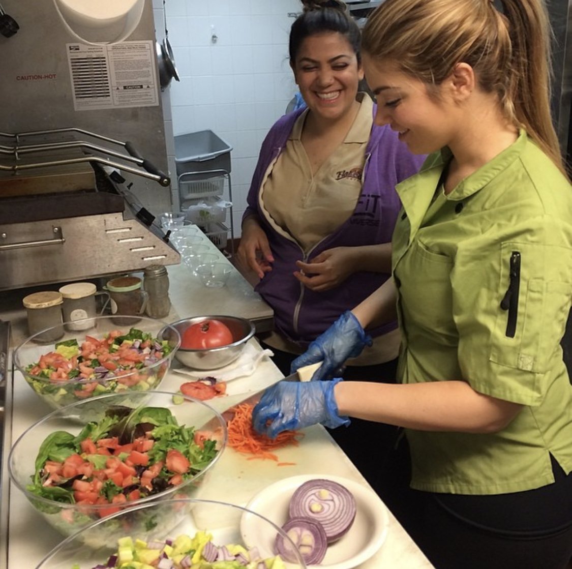 Two of the Esendemir sisters prepping food in the Flatbread Grill® kitchen