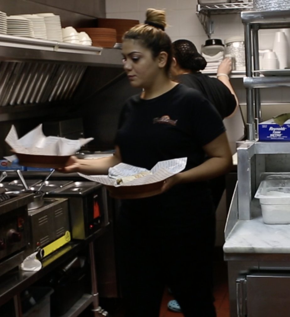 The Esendemir sisters serving food in the Flatbread Grill® kitchen