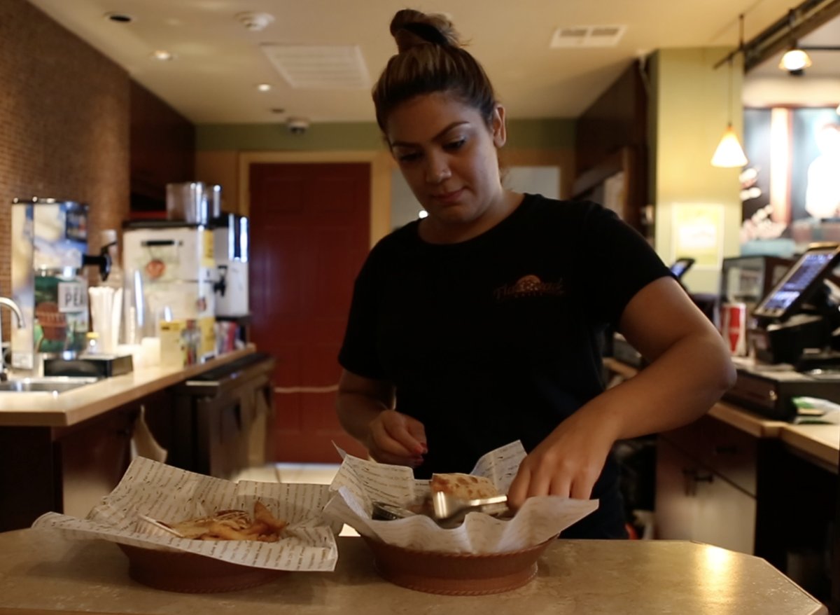 One of the Esendemir sisters behind the counter at Flatbread Grill®