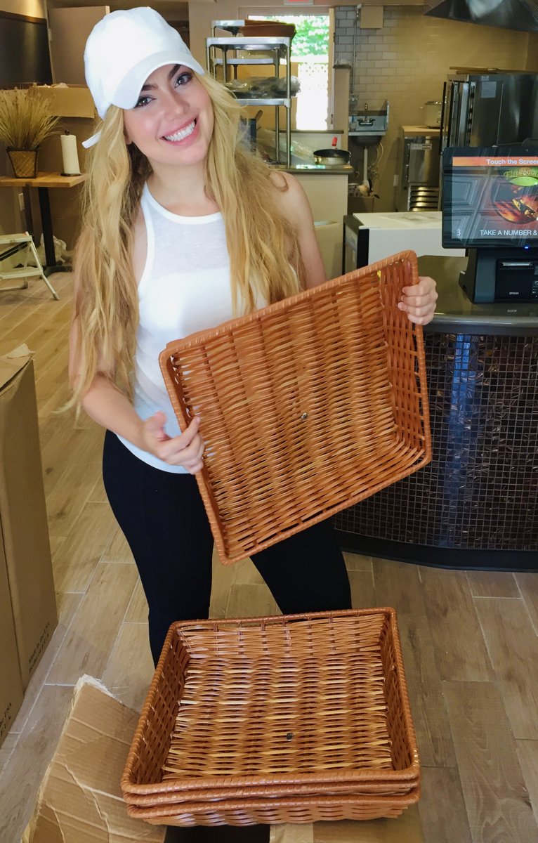 One of the Esendemir sisters holding bread baskets while setting up Flatbread Grill®
