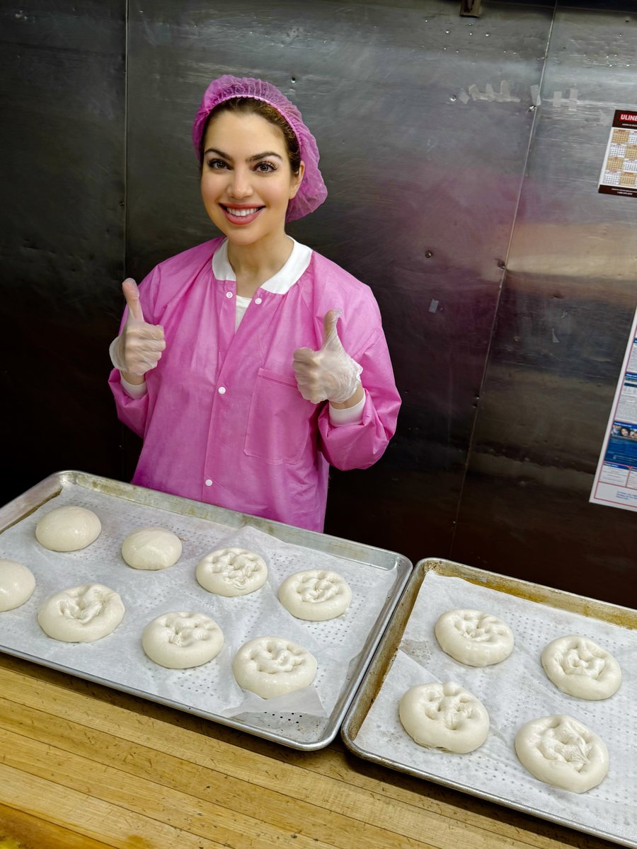 One of the Esendemir sisters giving a thumbs up over trays of Thumb Bread® dough