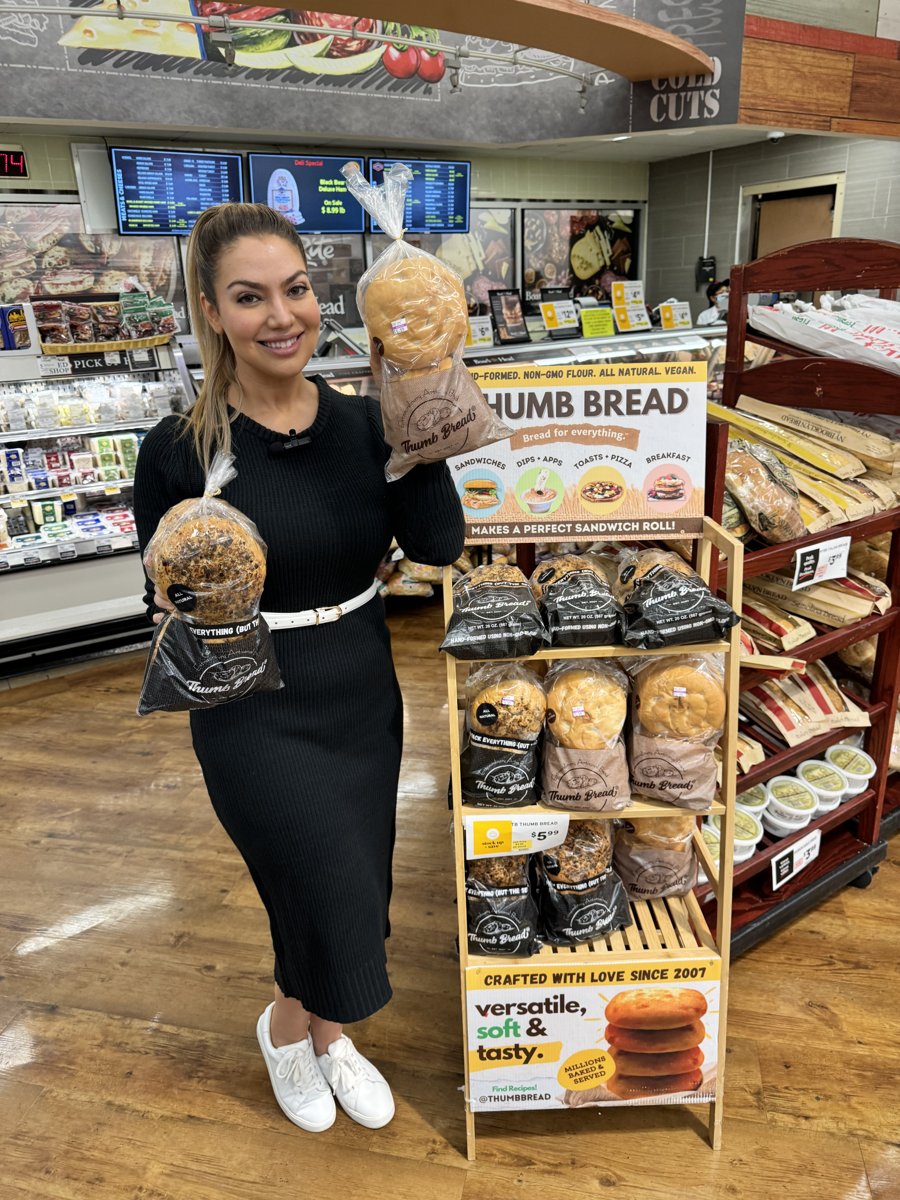 One of the Esendemir sisters holding Thumb Bread® next to its in-store display